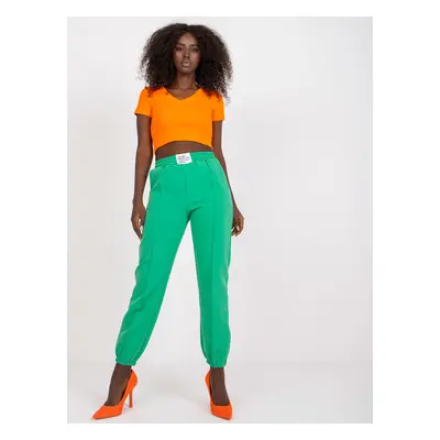 Dark green women's trousers made of fabric with wrinkled